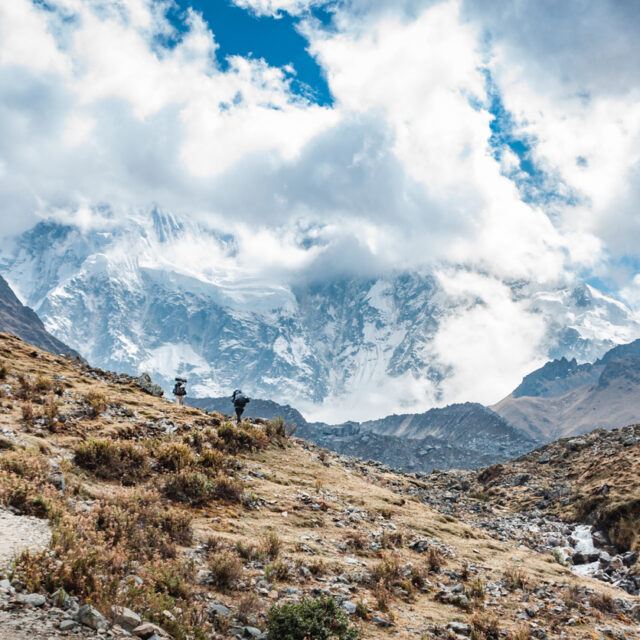 Backpackers hiking at the Salkantay trek that goes from mollepata until machu picchu, with the salkantay mountain in the background