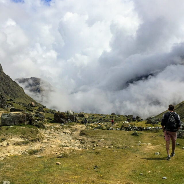 Man walking into the clouds high in the Andes Mountains along the Salkantay Trek in Peru