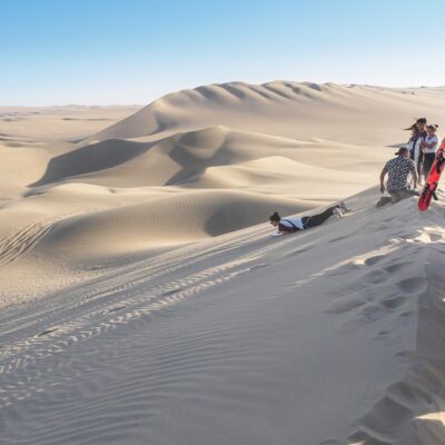 Huacachina, Peru - Oct 2, 2017: Tourists are joining the most famous tour, the sandboarding.