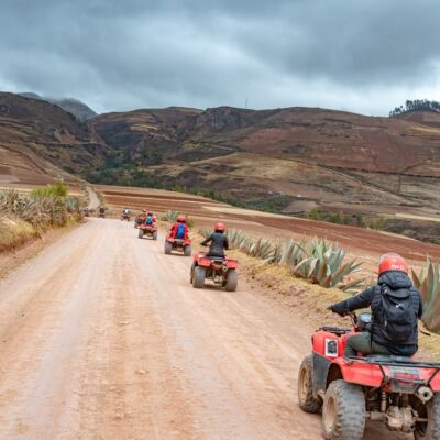 Maras,Peru - October 15, 2018: Tourists are riding ATVs going to the Ollantaytambo on the dirt road from Moray.