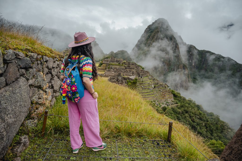A visitor looking out over a cloud-covered Machu Picchu