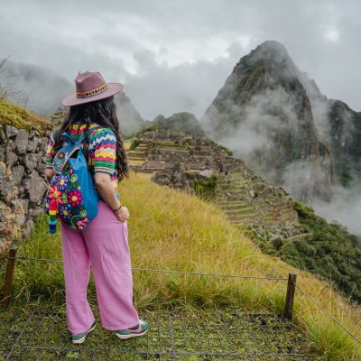 A visitor looking out over a cloud-covered Machu Picchu